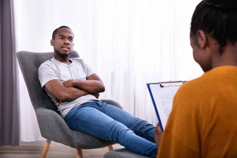 Man Sitting On Chair Near Psychologist