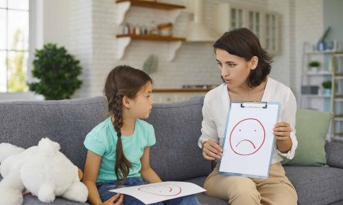 Psychologist with picture of unhappy emoji helping